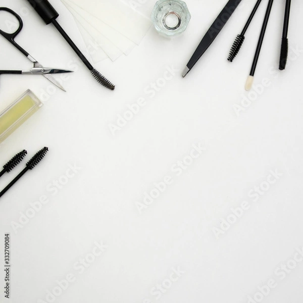 Fototapeta Brow artist tools creating a decorative frame in a flat lay style on a white background
