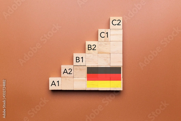 Fototapeta Wooden cubes with language levels, concept of learning and improvement. German language