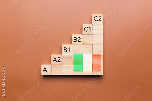 Fototapeta Wooden cubes with language levels, concept of learning and improvement. Italian language