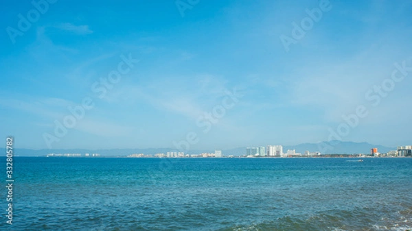 Obraz Bright Blue Ocean Beach With Buildings in the Background In Puerto Vallarta Mexico
