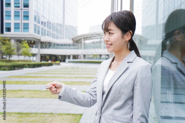 Fototapeta オフィス街でキャッシュレス決済をするビジネスウーマン