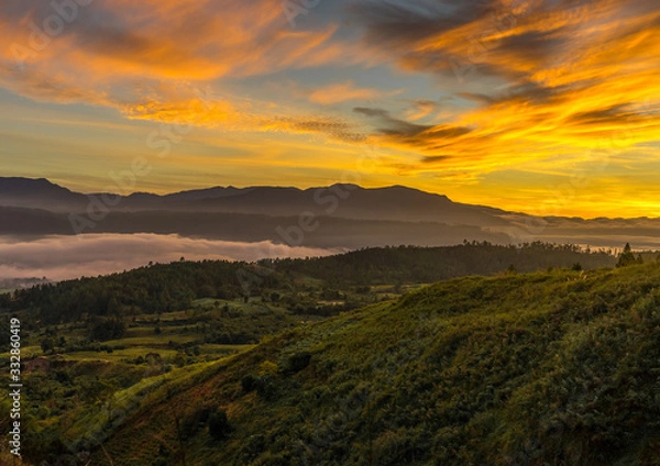 Obraz Bright golden sunrise Sea of clouds above Blangkejeren town but below impressive Bukit Barisan mountain range seen from Kedah, Banda Aceh while wild camping on a hill near Leuser ecosystem