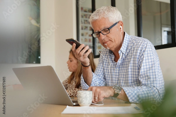 Obraz senior man working on his computer at home
