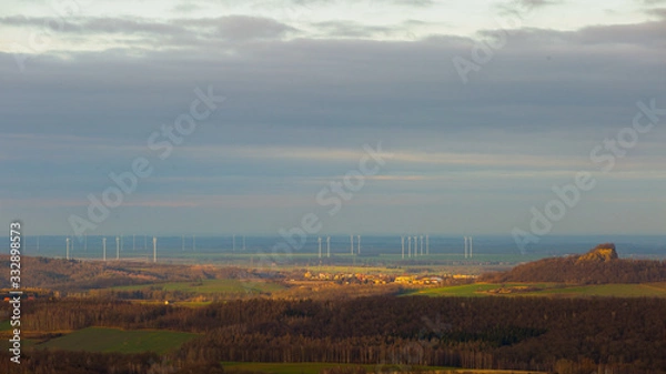 Fototapeta Clouds rolling in the wind over the peaceful windmills and town of Zlotoryja, Poland