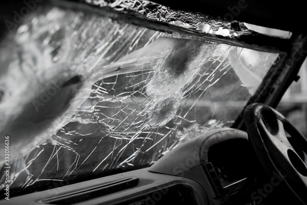 Fototapeta Bullet hole on a car windshield. Car window after a raid has a bullet hole. Broken glass. Bullet holes in a front windshield. Broken Windshield.