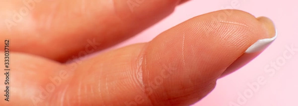 Obraz female hand finger inner side, close-up on a pink background. fingertips