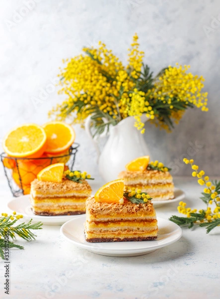 Obraz Orange cake decorated with fresh orange slices and mimosa flowers on light background