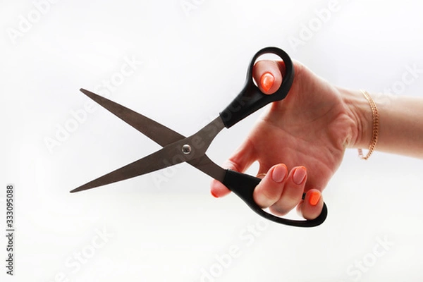 Obraz female hand holds cuts with scissors