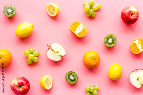 Fototapeta Colorful fruit pattern. Cut apple, kiwi, citrus on pink background top-down