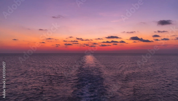 Fototapeta Open sea travel by ferry. Enjoying impressive vivid sunset from a boat while on boat in Indonesian waters, Java sea near near Sulawesi and Kalimantan. Exploring the sea