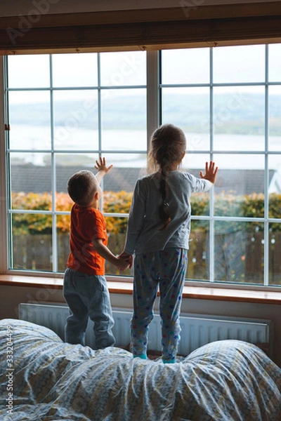 Fototapeta children holding hands and touching window