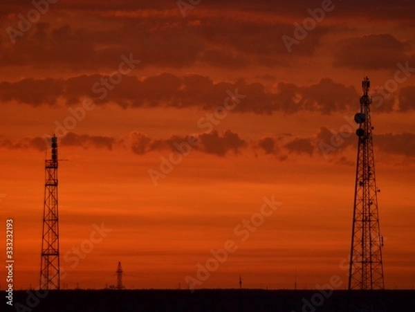 Obraz  Orange sunset, colorful sky. The clouds. voltage electric tower. Golden sky and white clouds. Beautiful cloudscape. Nature background. Transmission lines. Peaceful and tranquil abstract background. S