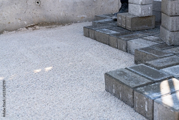 Obraz Workers lay paving tiles, construction of brick pavement, close up architecture background stock photo...