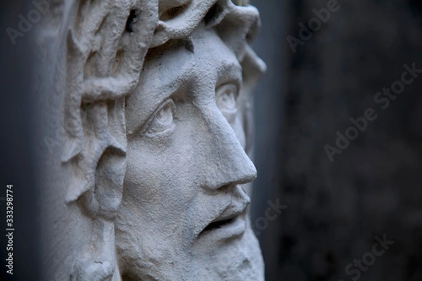 Obraz Ancient statue of Jesus Christ in profile against dark background. Religion, faith, death God concept.