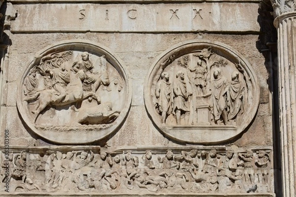 Fototapeta The Arch of Constantine is located next to the Colosseum in Rome. Via di San Gregorio street. The bas-reliefs of the arch were removed from other architectural structures. Three-span gate.