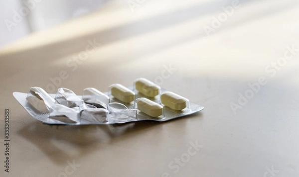 Fototapeta Close-up of pills in a packet on a table