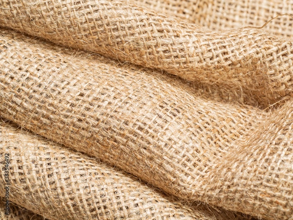 Fototapeta Close up view on brown crumpled burlap textile. Abstract background of brown sackcloth. Texture of brown burlap fabric. Selective soft focus. Blurred background