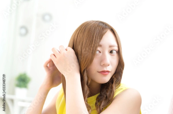 Obraz 鏡でスタイルを整える若い女性