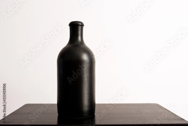 Obraz Black clay bottle on a white background