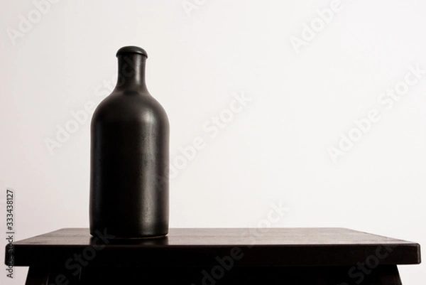 Obraz Black clay bottle on a white background