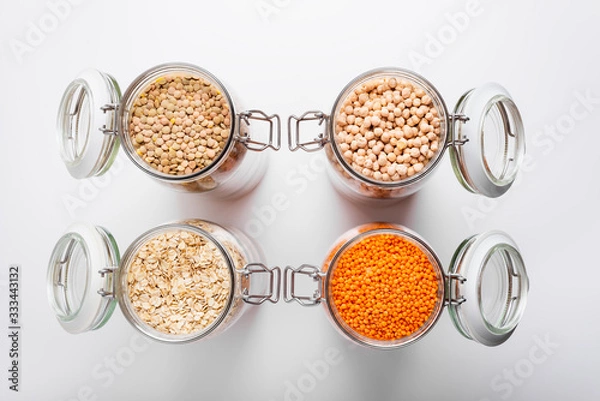 Obraz Dry lentils, oats and chickpeas in glass jars, top view