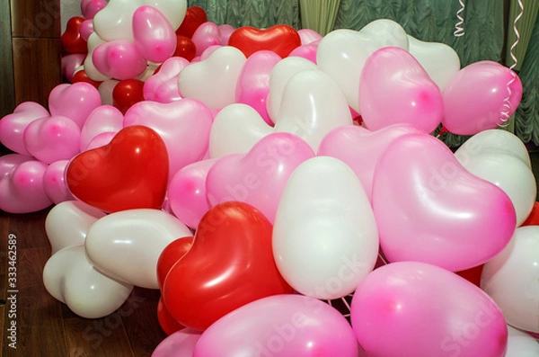 Obraz A large number of inflated multicolored heart-shaped balloons are stacked in bulk in the corner of the room for the upcoming holiday, close-up, copy space.
