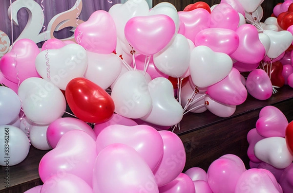 Obraz A large number of inflated multicolored heart-shaped balloons are stacked in bulk in the corner of the room for the upcoming holiday, close-up, copy space.