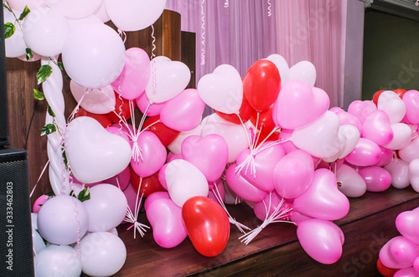 Obraz A large number of inflated multicolored heart-shaped balloons are stacked in bulk in the corner of the room for the upcoming holiday, close-up, copy space, toned.