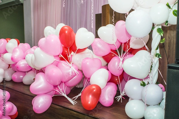 Obraz A large number of inflated multicolored heart-shaped balloons are stacked in bulk in the corner of the room for the upcoming holiday, close-up, copy space.