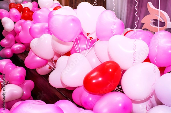 Obraz A large number of inflated multicolored heart-shaped balloons are stacked in bulk in the corner of the room for the upcoming holiday, close-up, copy space, toned.