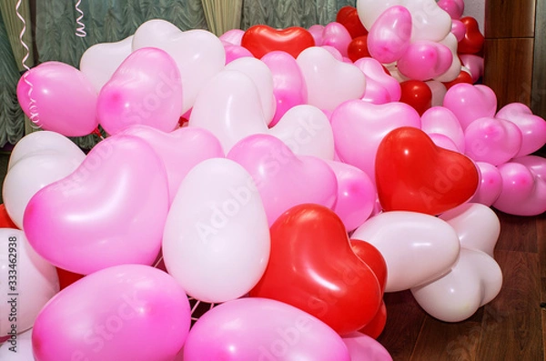 Obraz A large number of inflated multicolored heart-shaped balloons are stacked in bulk in the corner of the room for the upcoming holiday, close-up, copy space, toned.