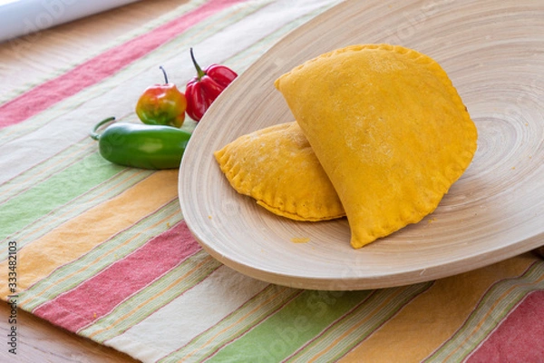 Obraz Jamaican pie in wooded plate with hot Peppers