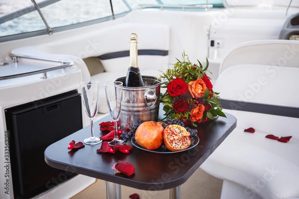 Fototapeta Table on a cruise yacht with cool champagne, flowers and fresh fruit.