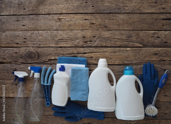 Fototapeta The concept of general cleaning with natural detergents. Plastic bottles of detergents on a wooden background. Cleaning and washing of the day.