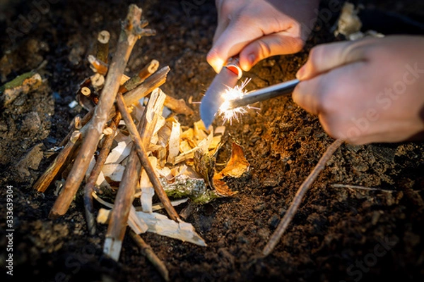 Obraz Outdoors makeing fire by flint. Closeup view.