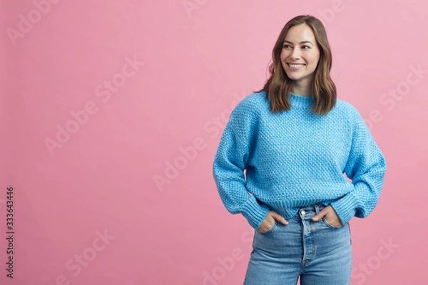 Fototapeta Sweet smiling girl, person and businesswoman in a winter sweater looking left at copy space, isolated on a colorful and coloured pink background.