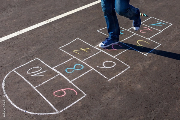 Obraz A young man playing hopscotch on asphalt.