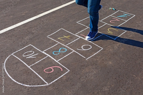 Obraz A young man playing hopscotch on asphalt.