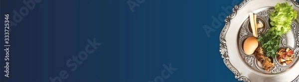 Fototapeta Pesach plate on a dark blue background, wide banner with a copyspace. Traditional Jewish seder on the occasion of Passover festival.