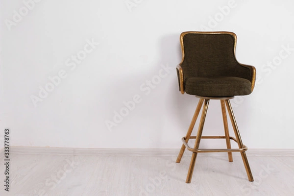 Fototapeta green bar stool with soft upholstery and gold legs on a white background