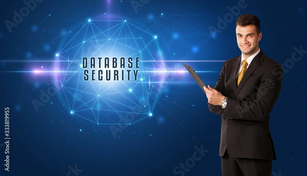 Fototapeta Businessman thinking about security solutions with DATABASE SECURITY inscription