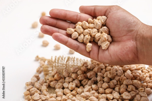 Fototapeta Uncooked dried chickpeas in hand