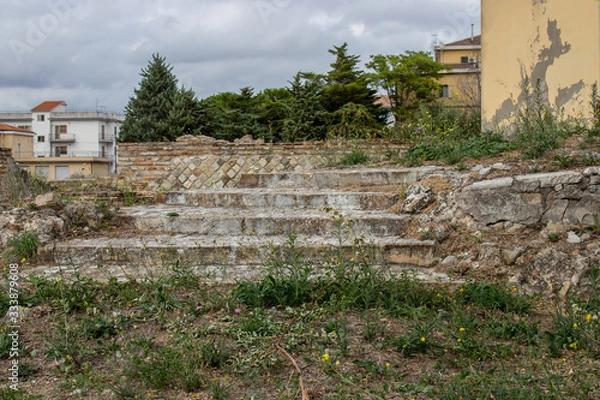 Obraz Larino, Campobasso, Roman archaeological site on the modern building background, on a sunny day