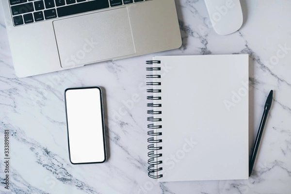 Obraz Modern marble office desk table with laptop, blank white mobile phone screen mockup and notebook page for input text or entry short note, copy space for creative content and design. Top view, flat lay