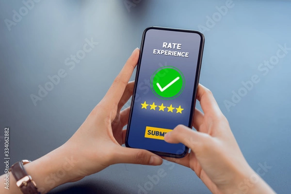 Fototapeta Hand holding smartphone rate your experience on application mobile.