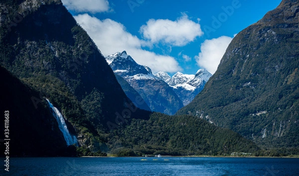 Obraz Gorgeous image of Milford Sound with a waterfall in the foreground and snow capped mountains in the background taken on a sunny spring day, New Zealand