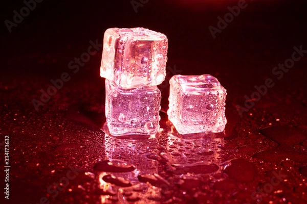 Fototapeta ice cubes on a reflections red light.