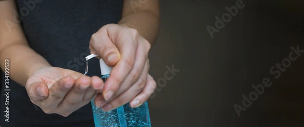 Fototapeta Close up woman's hand pressing alcohol gel from bottle, apply sanitizer gel for hand wash to make clean and clear germ, bacteria, and virus. Pandemic protection and Hygienic concept, selective focus