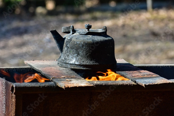 Fototapeta Old kettle on the grill. Tea in nature. Kettle on the fire.