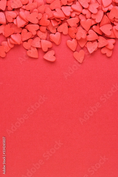 Obraz many red hearts are scattered on a red background, top view
